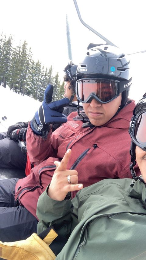 Latinx team in snowboard gear on a chair lift at Mt Bachelor Ski Resort for Vamonos Outside program holding peace sign.